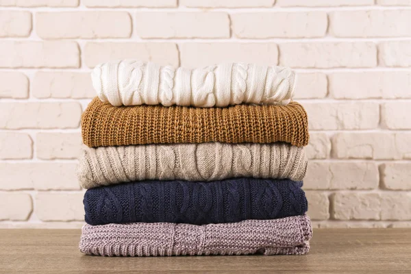 Stos dzianiny swetry o różnych kolorach i wzorach idealnie ułożone. — Zdjęcie stockowe