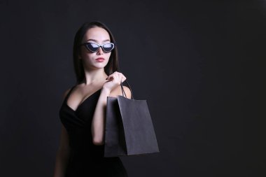 Koyu arka planda kese kağıdı olan güzel bir kadın..