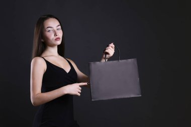 Koyu arka planda kese kağıdı olan güzel bir kadın..