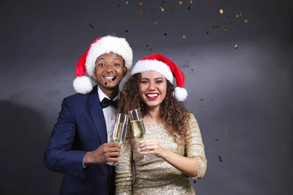 Studio portret van jong stel, vriendje dragen pak & vriendin in sexy jurk met glitter, kerstman hoed en kerst outfit. Close up, kopieerruimte voor tekst, geïsoleerde achtergrond. — Stockfoto