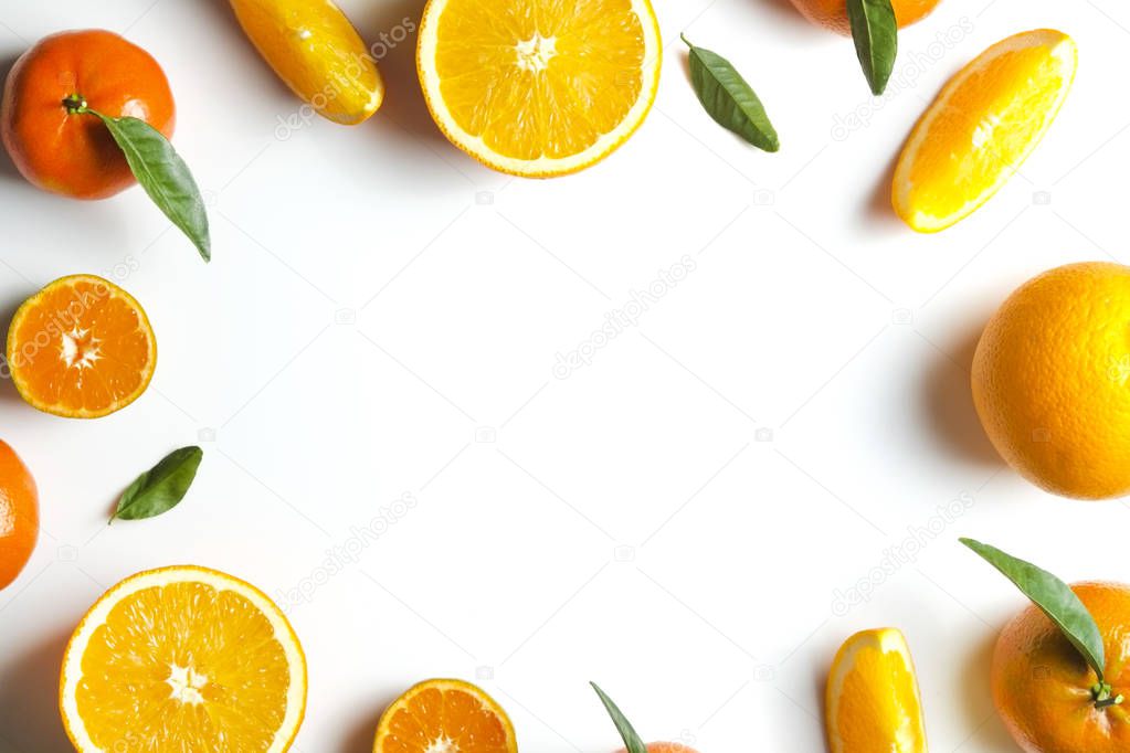 Close up image of juicy organic whole and halved oranges with green leaves & visible core texture, isolated white background, copy space. Macro shot of bright citrus fruit slices. Top view, flat lay.