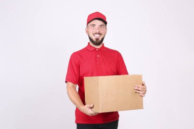 Kurye teslimat konsepti. Kırmızı polo tişörtlü sakallı adam paketi tutuyor..