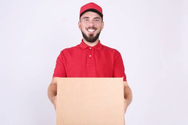 Kurye teslimat konsepti. Kırmızı polo tişörtlü sakallı adam paketi tutuyor..
