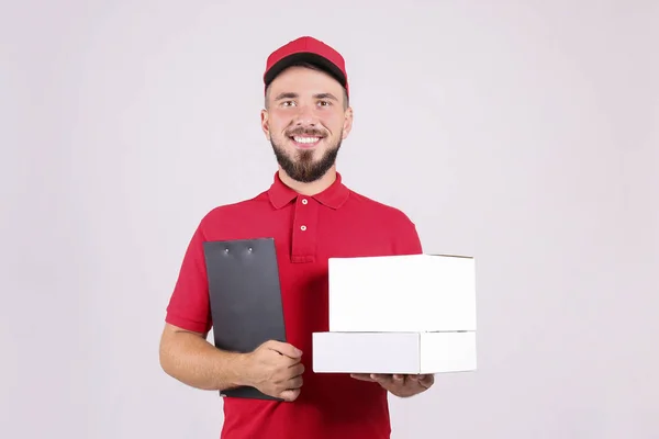 Courier delivery concept. Bearded man in red polo shirt holding the parcel.