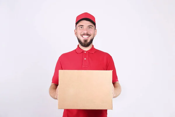 Conceito de entrega de correio. Homem barbudo com camisa de pólo vermelho segurando o pacote . — Fotografia de Stock