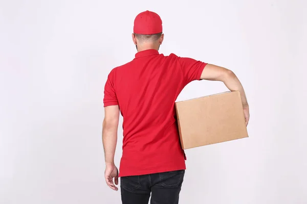 Courier delivery concept. Bearded man in red polo shirt holding the parcel. — Stock Photo, Image