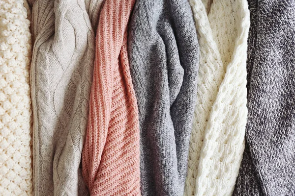 Купка в'язаних светрів різних кольорів і візерунків ідеально складена . — стокове фото