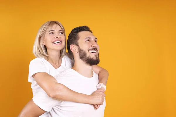 Young people of opposite sex and hair color on yellow background. — Stock Photo, Image
