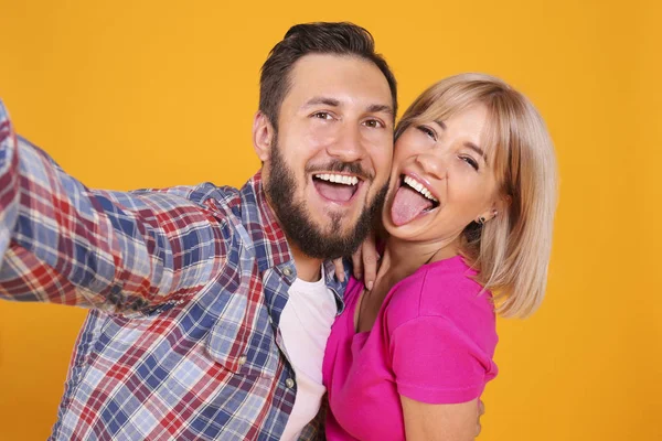 Young people of opposite sex and hair color on yellow background. — ストック写真