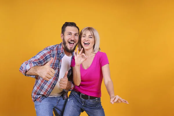 Young people of opposite sex and hair color on yellow background. — ストック写真