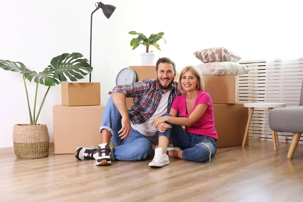 Joven pareja casada mudándose en nuevo apartamento, sentado en el flo — Foto de Stock