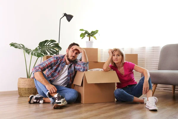 Joven pareja casada mudándose en nuevo apartamento, sentado en el flo — Foto de Stock