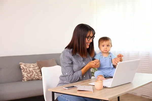 Ung mamma arbetar på hemmakontoret med sitt barn, vit vägg bakgrund med kopieringsutrymme. — Stockfoto