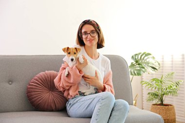 Genç ve güzel hippi kadının portresi ve dört aylık sevimli köpeği Jack Russell Terrier evde, oturma odasında güneş ışığıyla dolu. Lofty iç arkaplan, kapat, kopyala boşluk.