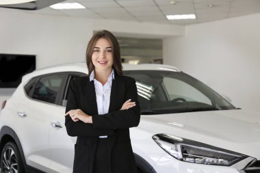 Bir grup araba ve satış temsilcisinin bulunduğu geniş bir otomobil galerisi.