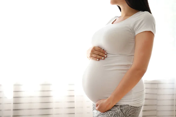 Giovane donna che tiene la pancia incinta il nono mese di gravidanza . — Foto Stock