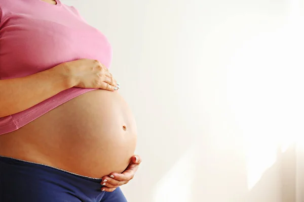 Jeune femme tenant son ventre enceinte le neuvième mois de grossesse . — Photo