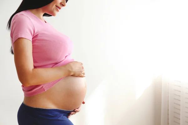 Close Up of Pregnant Woman Wearing Supportive Seamless Maternity Bra & Grey  Yoga Pants, Arms on Her Belly. Female Hands Wrapped Stock Photo - Image of  hands, maternity: 194196910