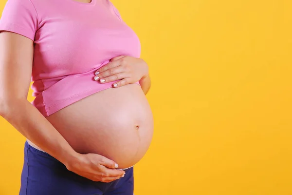 Молода жінка тримає живіт на дев'ятому місяці вагітності . — стокове фото