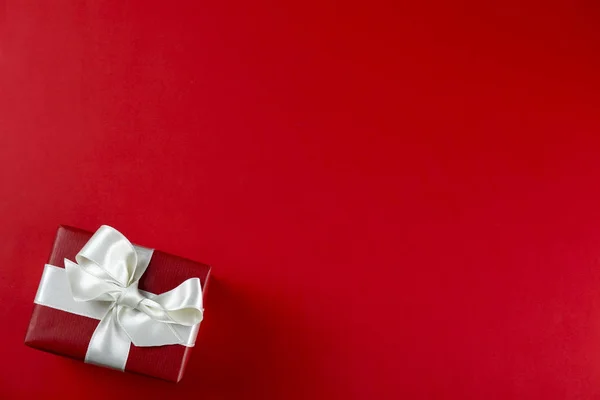 Куча рождественских подарков, завернутых в красно-белую бумагу, завязанную блестящим шелковым бантом. Множество новогодних подарков в красно-белой упаковке. Вид сверху, крупный план, копировальное пространство, фон, плоская кладка . — стоковое фото