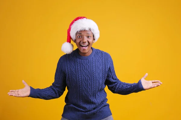 Αφροαμερικανός άνδρας φορώντας κομψό καρό πουκάμισο μεγάλο χαμόγελο σε καπέλο santa με κουτί δώρου σε κίτρινο φόντο studio.dark-skin Άγιος Βασίλης συγχαίροντας Καλά Χριστούγεννα — Φωτογραφία Αρχείου