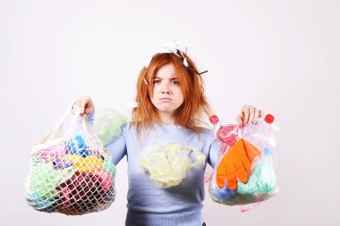 Duygusal kızıl saçlı kadın stresli görünümlü, eko zararlı plastik çöp, çanta ve farklı renk pipetler ile kaplı. Sıfır atık kavramı. Üzgün kadın kaşlarını çatma, çöp hakkında kızgın.