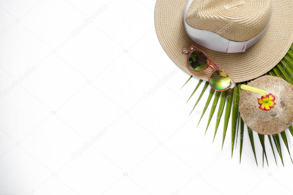 Summer mood concept. Tropical background with fresh whole coconut with cocktail straw, mirrored lense sunglasses and sugar palm leaves. Flat lay, top view, close up copy space, isolated.