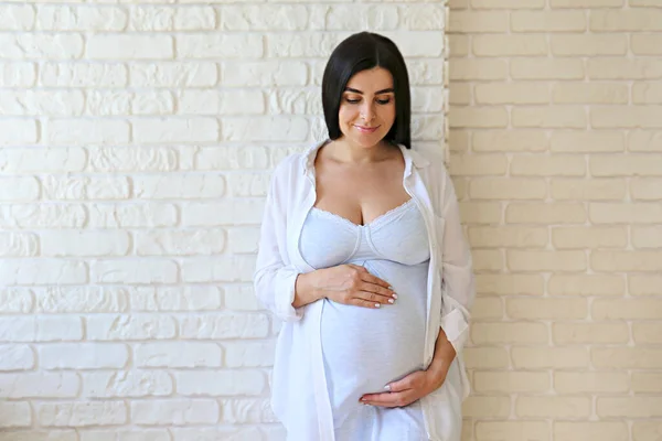 Hamileliğin Üçüncü Ayında Güzel Bir Kadının Portresi Kollarını Karnına Dayamış — Stok fotoğraf