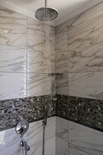 シャワーキャビンは自然光でいっぱい シャワーヘッドはランニングウォーターで天井に取り付けられます 大理石のテクスチャの壁のタイル コピースペース — ストック写真