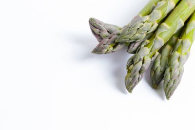 Bir grup çiğ kuşkonmaz beyaza izole edilmiş. Yenilebilir kuşkonmaz resmi filizleri kağıda dökülmüş arka planda. Kapat, boşluğu kopyala, üst görünüm, düz yatış.