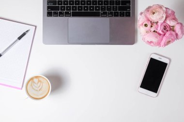 Kırpılmış çekim ya da dizüstü bilgisayar klavyesi, cappuccino ve dokuma sehpasında metin için bolca fotokopi alanı olan bir buket ranunculus çiçeği. Kapat, üst görünüm.