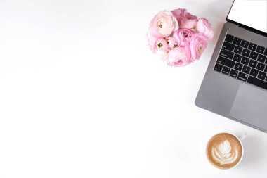 Kırpılmış çekim ya da dizüstü bilgisayar klavyesi, cappuccino ve dokuma sehpasında metin için bolca fotokopi alanı olan bir buket ranunculus çiçeği. Kapat, üst görünüm.