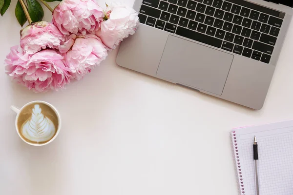 Kırpılmış çekim ya da dizüstü bilgisayar klavyesi, kapuçino ve desenli masa üzerindeki yazı için bir sürü kopya alanı olan şakayık çiçekleri. Kapat, üst görünüm.