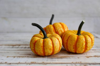 Homurdanmış ahşap dokular üzerinde iki dekoratif balkabağı yakın çekim arka plan parlak bir simge olarak sonbahar tatillerinde metin için bir sürü kopya alanı ile.