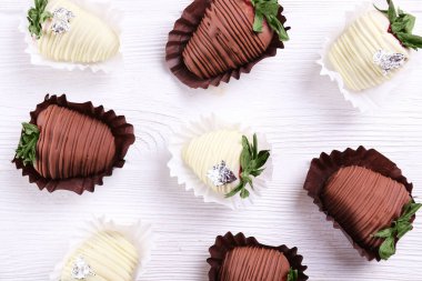 Romantik bir jest olarak çeşitli çikolata kaplı çilekler. Klas tatlı çöl, koyu renkli böğürtlen ve beyaz çikolata. Kapat, boşluğu kopyala, üst görünüm, izole arkaplan.