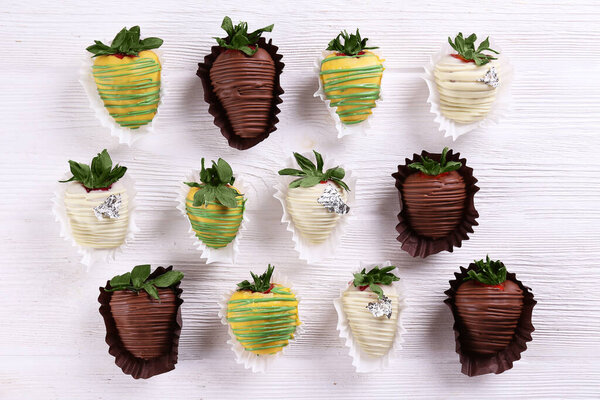 Разнообразный шоколад покрыл клубнику как романтический жест. Классическая сладкая пустыня, ягоды, застекленные в темно-белом и фисташковом шоколаде. Закрыть, скопировать пространство, вид сверху, изолированный фон.