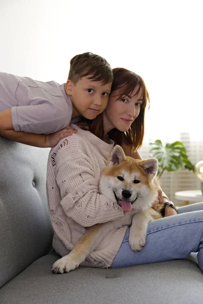 소파에 소년과 어머니가 개월된 일본산 리타이누 강아지와 엄마랑 재밌는 집에서 — 스톡 사진