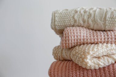 Bir sürü örülmüş pastel renkli süveter farklı örgü desenleri yığılmış, açıkça görülebilen doku. Şık sonbahar / kış mevsimi örgü giysileri. Kapat, metin için boşluk kopyala.