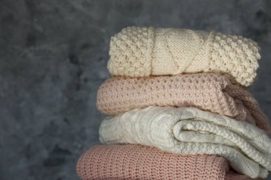 Bir sürü örülmüş pastel renkli süveter farklı örgü desenleri yığılmış, açıkça görülebilen doku. Şık sonbahar / kış mevsimi örgü giysileri. Kapat, metin için boşluk kopyala.
