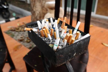 Sigaralar sigara içme alanındaki kül tablasında bırakılıyor.