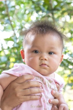 Anne, kızının kafasını elinde tutuyor..