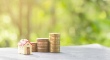 Ev ve madeni paralar ev almak için birikir. Emlak yatırımı ve konut kredisi finansal konsepti