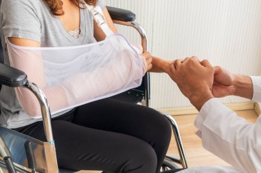 Genç doktor, kırık kollu ve tekerlekli sandalyedeki kadın hastayı teşvik etti..