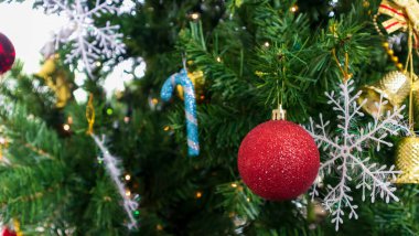 Kırmızı toplarla süslenmiş Noel ağacı beyaz bir duvarda oyuncaklar, kopyalama alanı.