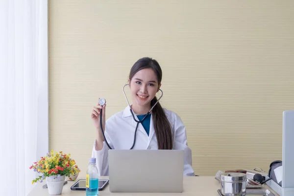 Asyalı kadın doktor bilgisayarın başına oturup mutlu bir şekilde gülümsedi..