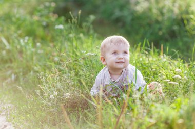 Çimde oturma sevimli küçük sarışın çocuk portresi