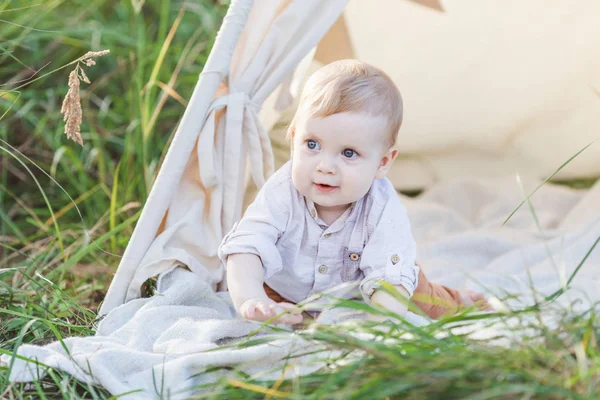 Um ano bonito menino em um teepee ao ar livre . — Fotografia de Stock