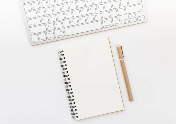 Blank notebook, pen and keyboard on white background. Notepad space for text input