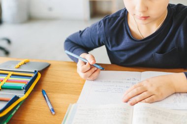 Liseli evde masa üzerinde Ukrayna dilde matematik ödevini yapıyor. Evde eğitim kavramı