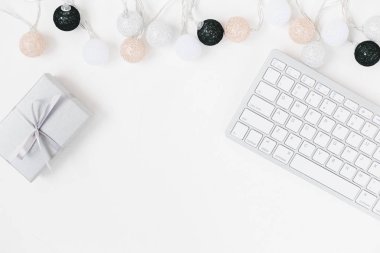 Beyaz klavye, küçük Hediyelik ve beyaz, siyah, altın, gümüş Noel ışık garland beyaz arka plan dokulu. Bloglama kopya alanı için tatil şablonu